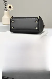 Detail showing the black handbag bottom with four protective gold metal feet studs