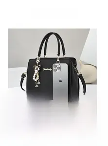 Comparaison de taille d'un sac à main noir en cuir Saffiano avec un iPhone pour échelle