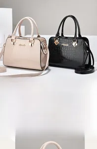 Detailansicht der Handtaschen mit Steinmuster, Metallgriffen und abnehmbaren Trageriemen