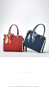 Detail of red and navy blue textured leather handbags with elegant silk scarves on handles