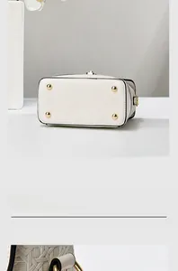 Detailed macro view of white leather bag base with golden protective metal studs