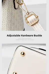 Detail of detachable gold lobster clasp and protective metal feet on beige woven bag