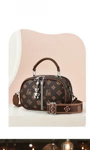 Détail du sac à main marron vintage avec breloque ours et large bandoulière fleurie