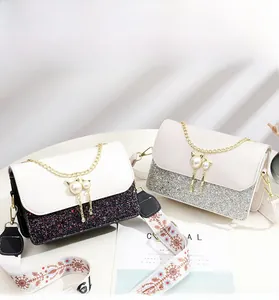Detail of sequin crossbody bags featuring pearl cat ear clasps and printed wide straps