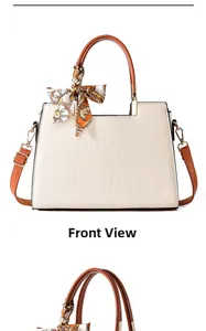 Close-up of cream crocodile pattern handbag with brown handle and decorative silk scarf