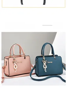 Vue détaillée de sacs à main structurés avec pendentifs nœuds dorés en rose et bleu