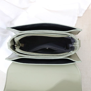 Top view of green leather crossbody bag showing internal compartments and zipper