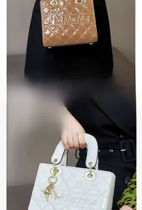 Close-up of structured patent leather handbags with classic quilted stitching and metal charms