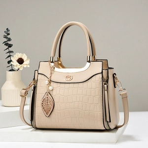 Elegant beige crocodile pattern handbag for women with metallic leaf charm and top handle