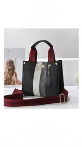 Detail of contrast stripe tote bag with woven texture and adjustable striped shoulder strap