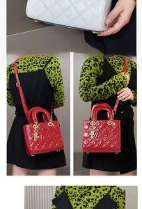 Detailed view of quilted patent leather handbags in red and white with metal charms