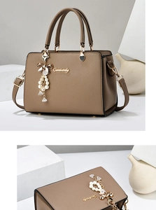Détail d'un sac à main marron avec texture Saffiano et breloque noeud en perles