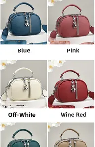 Detailed view of leather handbag with bear charm, tassel and stylish wide strap