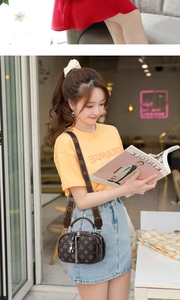 Vue détaillée du petit sac bandoulière marron à monogramme avec pompon et multi-fermetures