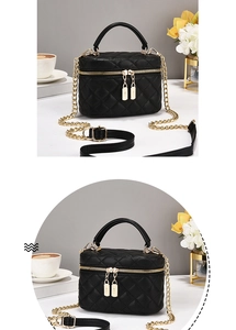 Detailansicht der schwarzen gesteppten Box-Tasche mit goldenen Beschlägen und Doppelreißverschluss