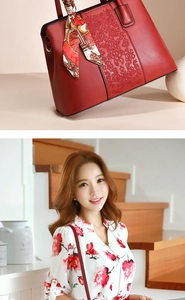 Detail of red leather handbag featuring floral embroidery and a printed silk scarf handle