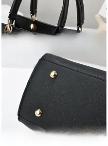 Vue détaillée du sac à main noir avec garnitures dorées et rivets de protection sur le fond