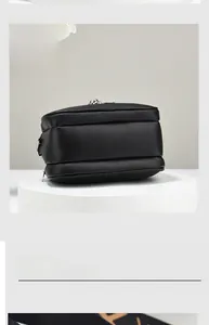 Detail of black lychee grain leather camera bag with dual zipper and embossed metal hardware