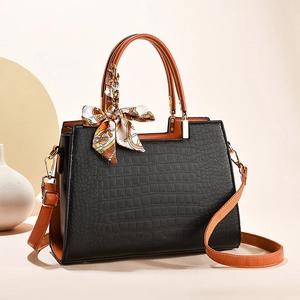 Women's black crocodile embossed handbag with orange handles and silk scarf detail