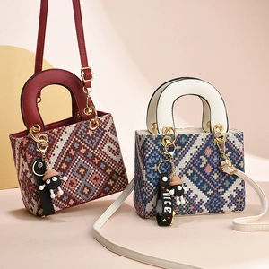 Chic jacquard canvas tote bag with leather handles and a cute fuzzy soot sprite charm