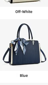 Detail of ripple texture leather handbag with floral scarf and gold hardware in blue and beige