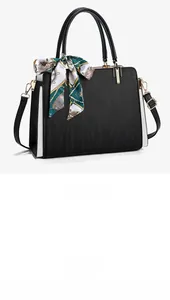 Detail of black textured tote bag with vertical stripes and silk scarf handle accent