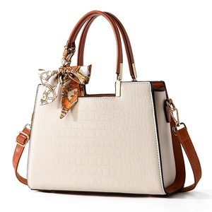 Chic beige crocodile texture tote bag with brown handles and elegant silk scarf detail