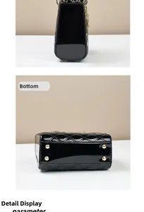 Detail view of the black quilted patent leather handbag base with gold protective studs