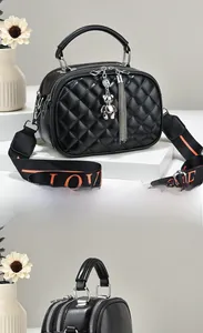 Close-up of quilted black leather handbag with bear charm and silver tassel detail
