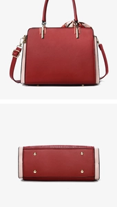 Detailed bottom view of red leather handbag showing metal feet and silk scarf handle