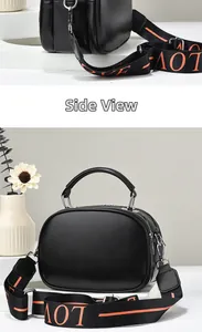 Detail view of black quilted handbag featuring a wide Love pattern strap and top handle