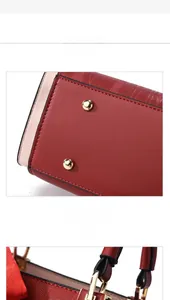 Detail of red handbag showing gold-tone hardware and protective bottom metal rivets