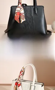 Detail of floral embossed leather handbag with silk scarf handle and metal clasp in two colors