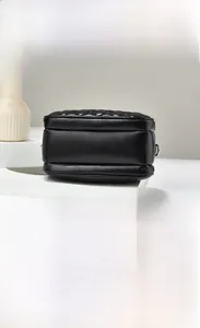 Detailed back and bottom view of black quilted crossbody bag with silver hardware
