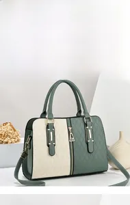 Detail of color-block handbag with forest green and cream geometric quilted patterns