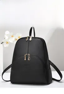 Close-up of black lychee grain leather backpack with gold zippers and brand logo detail