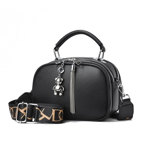 Chic black pebble leather handbag with wide logo strap and silver bear charm