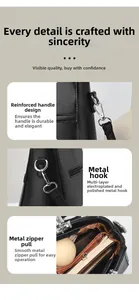 Detail view of reinforced handles, polished gold-tone hardware and smooth zipper on black bag