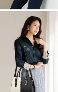 Detail of elegant two-tone handbag styled with a contrasting long-sleeve blouse and skirt