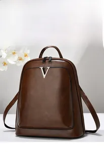 Détail d'un sac à dos vintage marron imperméable avec logo V argenté et fini texturé
