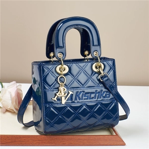 Navy blue patent leather quilted handbag with gold metal charms and crossbody strap