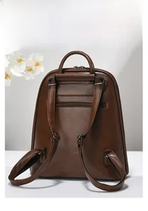 Détail du dos du sac à dos en cuir marron avec bretelles réglables et poche zippée