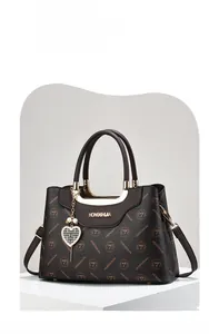 Detailed close-up of dark brown monogram pattern with elegant golden metal logo and handle