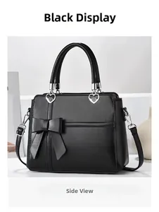 Detail of black PU leather tote with a large bow and silver heart-shaped hardware