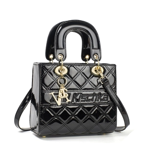 Classic black patent leather handbag with quilted stitching and gold letter charms