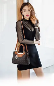 Fashionable dark coffee floral handbag with leather handles and heart pendant detail