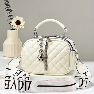 Quilted cream crossbody bag with chain handle and LOVE lettered woven shoulder strap