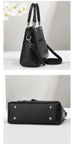 Detail view of black tote bag featuring bottom protective metal studs and side zipper pocket