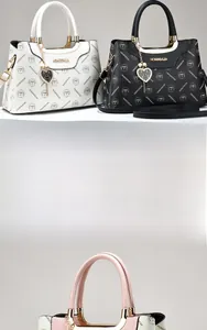 Detail of embossed leather texture and gold heart charm on stylish crossbody handbag