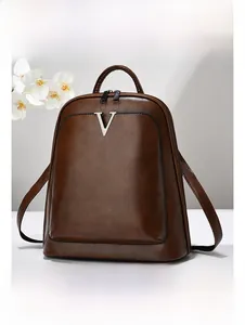 Détail du sac à dos en similicuir marron foncé avec logo V argenté et double fermeture éclair